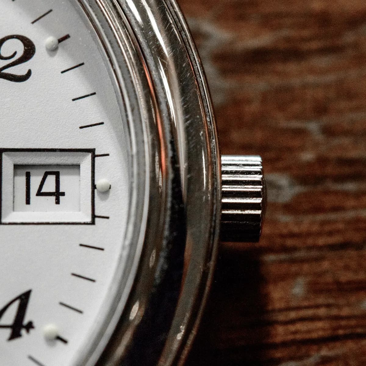 Macro detail of a watch face, light grazing the dial texture. Extremely shallow focus, cool metal tones, precise and tactile.