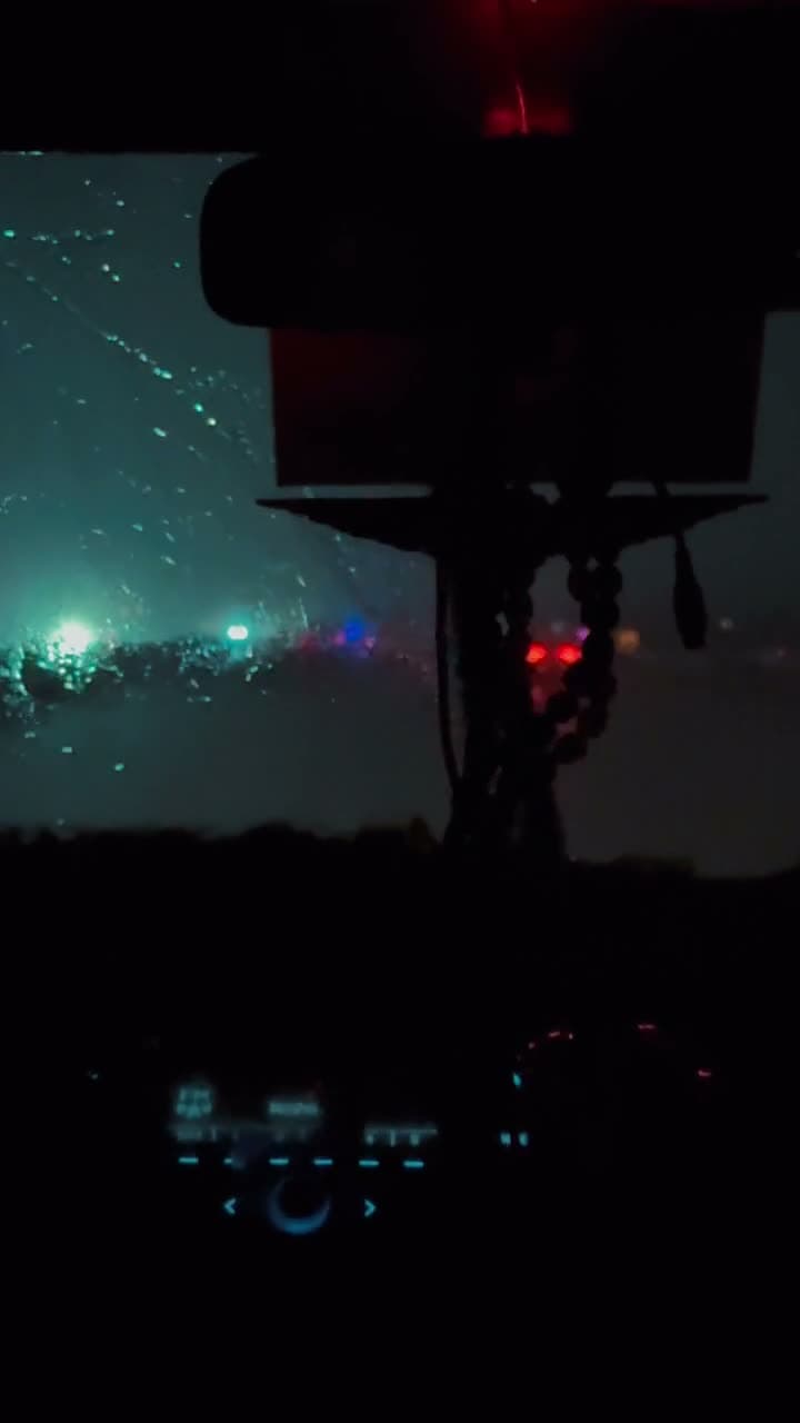 A rain-slicked neon street at night, camera pushing slowly forward past glowing signage. Reflections smear across the wet asphalt. Moody, saturated, cinematic.